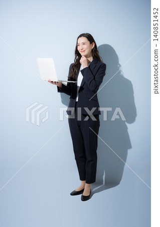 一張全身照,一位面帶微笑的日本女商人身穿西裝,在淺藍色背景下看著筆記型電腦,象徵數位轉型、人工智慧和業務改進。 一張全身照,一位面帶微笑的日本女商人身穿西裝,在淺藍色背景下看著筆記型電腦,象徵數位轉型、人工智慧和業務改進。 140851452