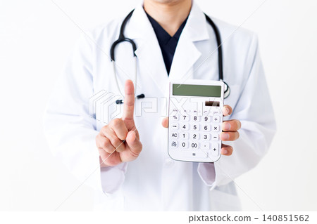 A middle-aged male doctor in a white coat holds a white calculator and raises his index finger. A middle-aged male doctor in a white coat holds a white calculator and raises his index finger. 140851562