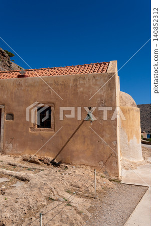 Historic stone church building under clear blue sky on Spinalonga island Greece Historic stone church building under clear blue sky on Spinalonga island Greece 140852312