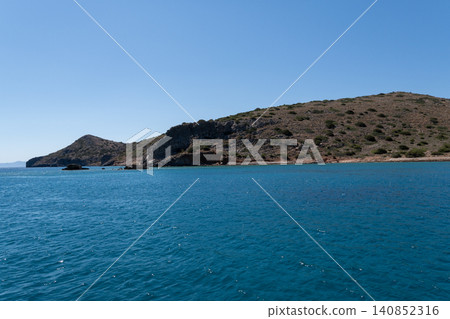 Scenic view of rocky mountains and blue sea on Spinalonga island Greece Scenic view of rocky mountains and blue sea on Spinalonga island Greece 140852316
