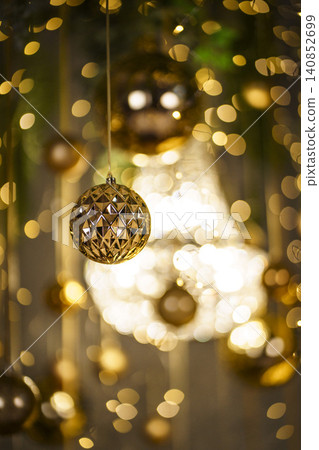 Golden Christmas Decorations with Hanging Ornaments and Festive Lights Golden Christmas Decorations with Hanging Ornaments and Festive Lights 140852699