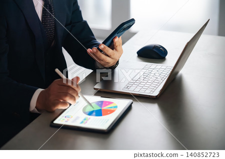 A male business person working using a smartphone and tablet PC. DX, SNS, desk work, work A male business person working using a smartphone and tablet PC. DX, SNS, desk work, work 140852723