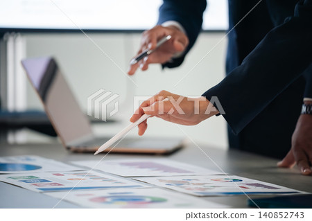 Male and female business professionals are having a meeting while looking at documents. Meeting, consultation, planning, discussion, training, guidance Male and female business professionals are having a meeting while looking at documents. Meeting, consultation, planning, discussion, training, guidance 140852743