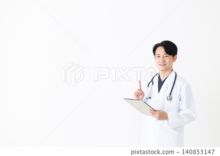 A middle-aged male doctor in a white coat holding a binder and raising his index finger. 140853147