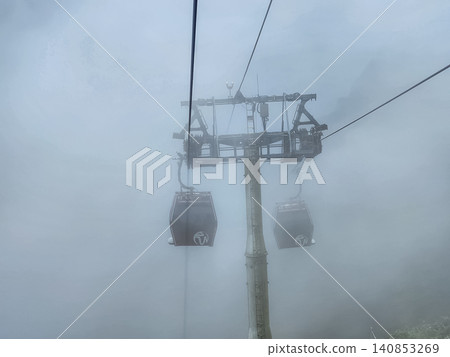 Genting Highlands cable car gondola with Coach branding in fog above mountain resort in Pahang Malaysia Genting Highlands cable car gondola with Coach branding in fog above mountain resort in Pahang Malaysia 140853269