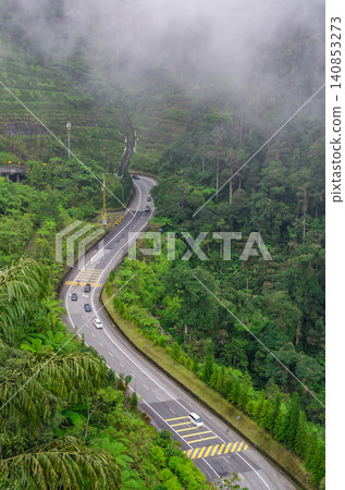 Winding mountain highway through tropical rainforest with mist and cars in Genting Highlands Malaysia Winding mountain highway through tropical rainforest with mist and cars in Genting Highlands Malaysia 140853273