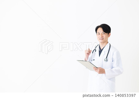 A middle-aged male doctor in a white coat makes a triumphant gesture while holding a binder. A middle-aged male doctor in a white coat makes a triumphant gesture while holding a binder. 140853397