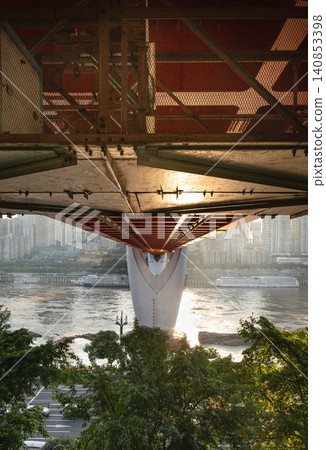 the striking underside of the Qiansimen Bridge one of Chongqing iconic Twin River Bridges stretches out like a massive geometric canopy; its bold red and white structure perfectly frames the shimmeri the striking underside of the Qiansimen Bridge one of Chongqing iconic Twin River Bridges stretches out like a massive geometric canopy; its bold red and white structure perfectly frames the shimmeri 140853398