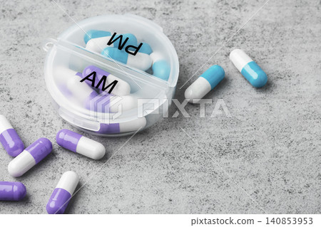 Capsule pills with daily pill box on a grey concrete background. Healthcare and medication concept, copy space Capsule pills with daily pill box on a grey concrete background. Healthcare and medication concept, copy space 140853953
