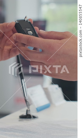 Vertical Video Young man selling car, handshake at car dealership with bought cars in background. Vertical Video Young man selling car, handshake at car dealership with bought cars in background. 140855547