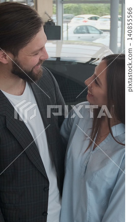 Vertical Video Visiting car dealership. Happy couple with new car key, smiling at camera. Vertical Video Visiting car dealership. Happy couple with new car key, smiling at camera. 140855566