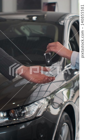 Vertical Video Happy man receiving keys to his new bought car with professional car dealer at the dealership salon cars sales business rent service automotive lifestyle. Vertical Video Happy man receiving keys to his new bought car with professional car dealer at the dealership salon cars sales business rent service automotive lifestyle. 140855581