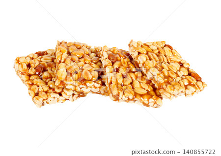 Four traditional Brazilian pe de moleque pieces made with caramelized peanuts, stacked and isolated against a white background Four traditional Brazilian pe de moleque pieces made with caramelized peanuts, stacked and isolated against a white background 140855722