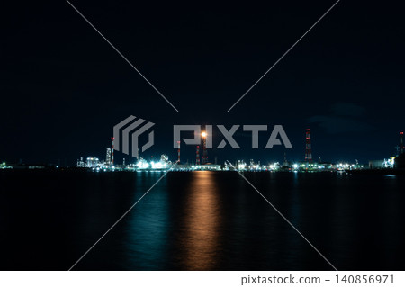 The factory night view across the sea and the lights reflected on the water's surface. The factory night view across the sea and the lights reflected on the water's surface. 140856971