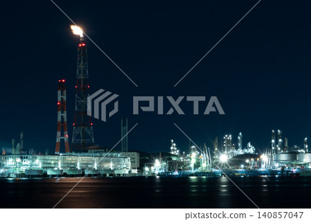 The factory night view of the Yokkaichi industrial complex, with flames from flare stacks shining brightly. The factory night view of the Yokkaichi industrial complex, with flames from flare stacks shining brightly. 140857047