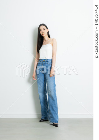 一位身穿牛仔褲的女模特 一位身穿牛仔褲的女模特 140857414