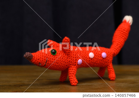 Handmade Red Knitted Dog on Dark Background Handmade Red Knitted Dog on Dark Background 140857466