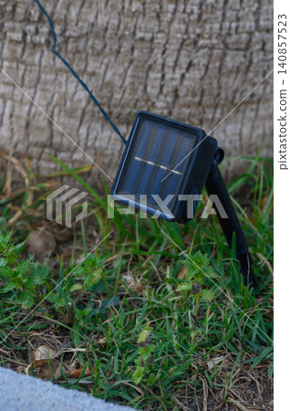 Solar-powered light illuminates garden area as night falls in a serene outdoor setting Solar-powered light illuminates garden area as night falls in a serene outdoor setting 140857523