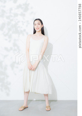 穿著白色洋裝的年輕女子 穿著白色洋裝的年輕女子 140857788