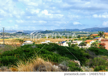 Picturesque Sicilian rural village surrounded by green hills and distant mountains. Picturesque Sicilian rural village surrounded by green hills and distant mountains. 140857813