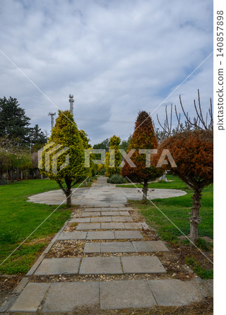 Beautiful landscaped pathway surrounded by vibrant trees in a serene park in springtime Beautiful landscaped pathway surrounded by vibrant trees in a serene park in springtime 140857898