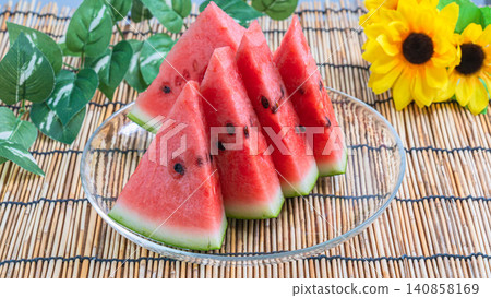 A summery image of sunflowers and watermelon: a refreshing dessert of sliced watermelon. A summery image of sunflowers and watermelon: a refreshing dessert of sliced watermelon. 140858169