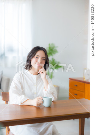Young woman drinking coffee in the living room 140858220