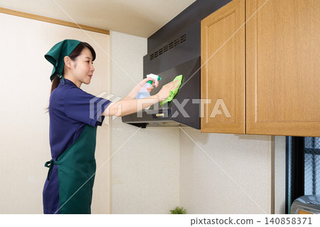 Female house cleaning staff cleaning a range hood Female house cleaning staff cleaning a range hood 140858371