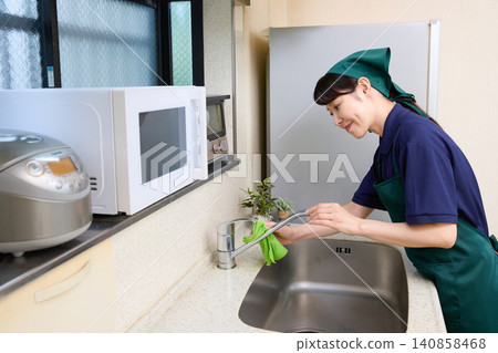 House cleaning staff cleaning the kitchen faucet 140858468
