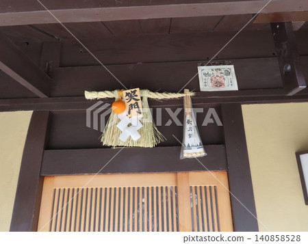 In the Hanamikoji alley in Gion, Kyoto, in a small alley at the back of the street, there was a shimenawa (sacred rope) and amulet attached to the entrance of a house in the passageway, a gate of laughter. In the Hanamikoji alley in Gion, Kyoto, in a small alley at the back of the street, there was a shimenawa (sacred rope) and amulet attached to the entrance of a house in the passageway, a gate of laughter. 140858528