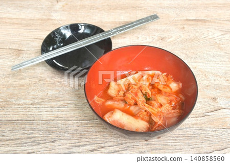 Kimchi pickled cabbage with sesame in salt Korean salad in red cup on table Kimchi pickled cabbage with sesame in salt Korean salad in red cup on table 140858560