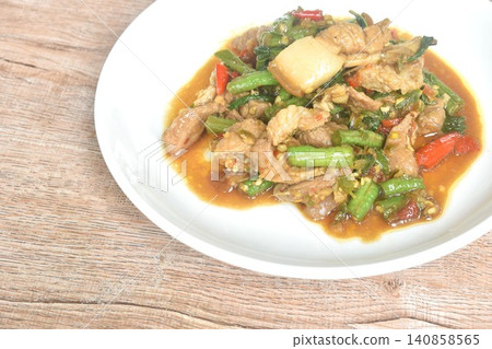 spicy stir fried fat pork belly couple slice yard long bean with basil on plate spicy stir fried fat pork belly couple slice yard long bean with basil on plate 140858565
