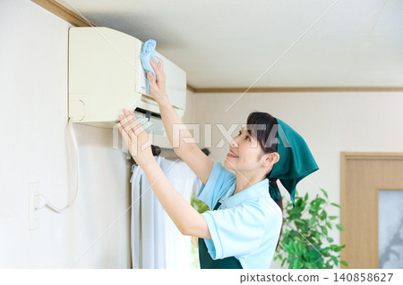House cleaning staff to remove dust from air conditioners House cleaning staff to remove dust from air conditioners 140858627