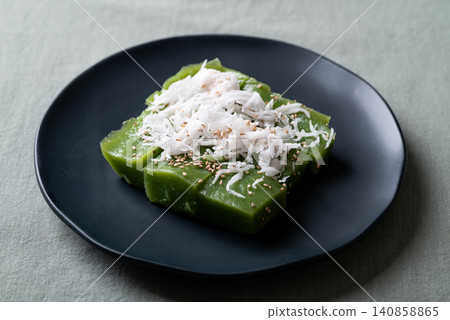 Traditional Thai dessert, pandan sweet pudding topped with coconut and toasted sesame seeds Traditional Thai dessert, pandan sweet pudding topped with coconut and toasted sesame seeds 140858865