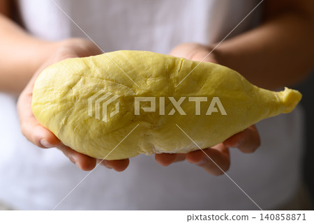 Ripe Thai durian fruit (Monthong) holding by woman hand ready to eating, tropical fruit in summer 140858871