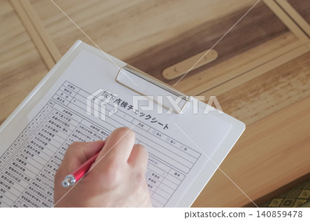 A worker inspects the area under the floor through an underfloor inspection hatch. A worker inspects the area under the floor through an underfloor inspection hatch. 140859478