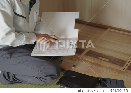 一名工人透過地板下的檢查艙口檢查地板下的區域。 一名工人透過地板下的檢查艙口檢查地板下的區域。 140859483