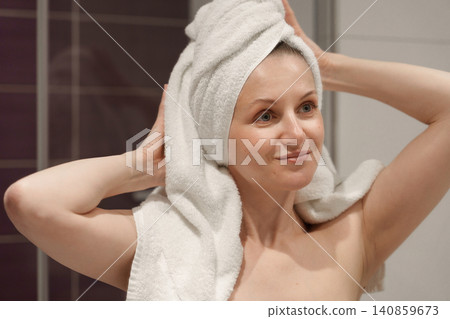 Smiling woman with towel on head after shower Smiling woman with towel on head after shower 140859673
