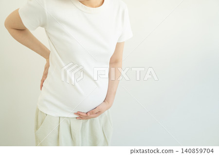 Pregnant woman suffering from backache. Cause of back pain during pregnancy include hormonal change, stress, postural changes and weight gain. Pregnancy health problems concept. Pregnant woman suffering from backache. Cause of back pain during pregnancy include hormonal change, stress, postural changes and weight gain. Pregnancy health problems concept. 140859704