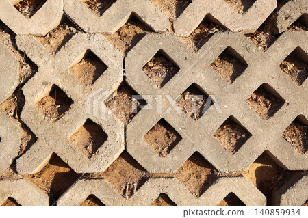 Close-up of a concrete fence with a large grid pattern, textured industrial wall structure Close-up of a concrete fence with a large grid pattern, textured industrial wall structure 140859934