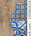 Vintage mismatched Portuguese tiles on cracked stucco 140860028