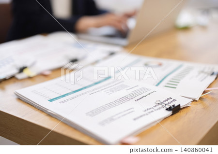 特寫鏡頭：一位女商人正在電腦前工作，辦公桌上擺放著文件。 140860041