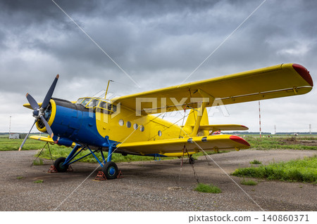 Yellow retro passenger biplane at the airfield Yellow retro passenger biplane at the airfield 140860371