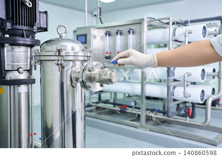 Gloved hand operating valve on industrial water purification system Gloved hand operating valve on industrial water purification system 140860598