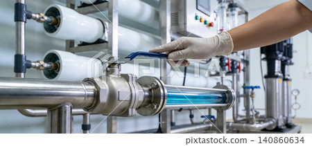 Operator adjusts valve on industrial water purification system with UV sterilization Operator adjusts valve on industrial water purification system with UV sterilization 140860634