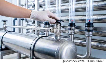 Gloved hand adjusts valve on industrial water purification system with flow meters Gloved hand adjusts valve on industrial water purification system with flow meters 140860663