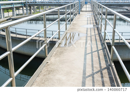 Worker inspects water treatment plant with flashlight on walkway Worker inspects water treatment plant with flashlight on walkway 140860717