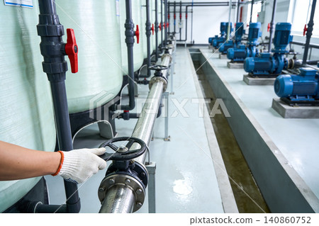 Industrial water treatment plant with technician operating valve and pumps Industrial water treatment plant with technician operating valve and pumps 140860752