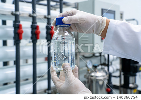 Scientist holding a clear bottle of water in a laboratory environment Scientist holding a clear bottle of water in a laboratory environment 140860754