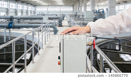 Industrial water treatment plant with operator overseeing operations and complex piping systems Industrial water treatment plant with operator overseeing operations and complex piping systems 140860770